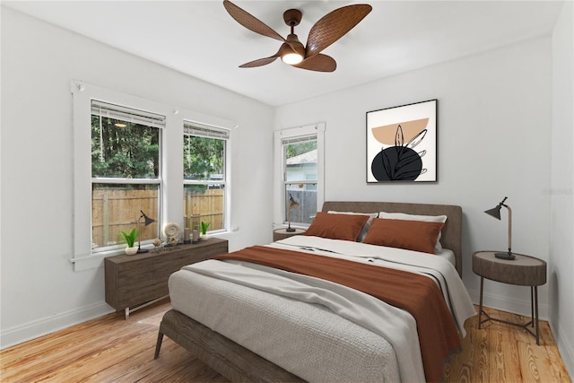 bedroom featuring baseboards, a ceiling fan, and wood finished floors