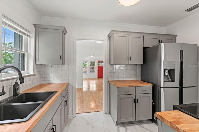 kitchen featuring a sink, gray cabinetry, and butcher block counters