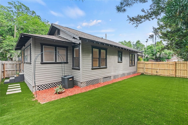 back of property with a yard, crawl space, central AC unit, and a fenced backyard