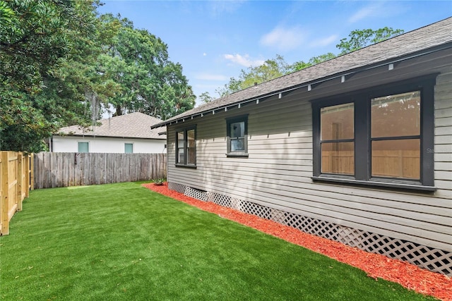 exterior space featuring a lawn, crawl space, a fenced backyard, and roof with shingles