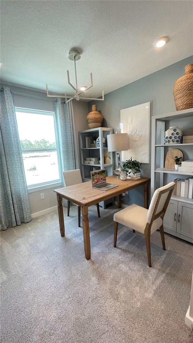 carpeted office space with baseboards and a textured ceiling