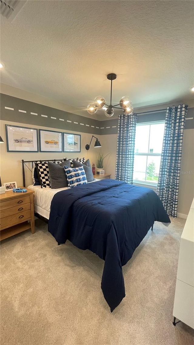 bedroom featuring a chandelier, a textured ceiling, light colored carpet, and visible vents