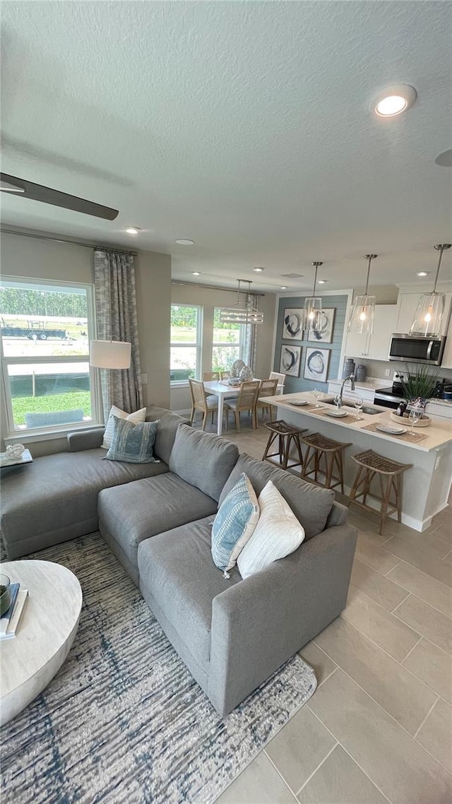 living room with a wealth of natural light, light tile patterned flooring, and a textured ceiling