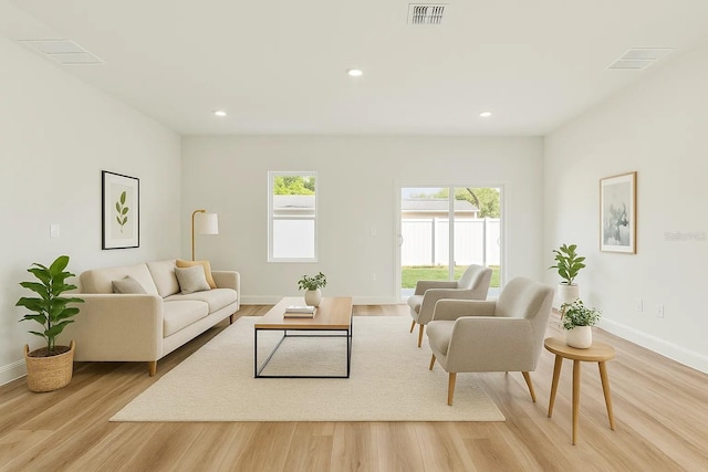 living room with light wood-type flooring, baseboards, and recessed lighting