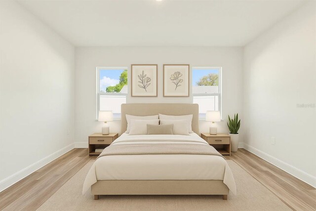 bedroom featuring light wood finished floors and baseboards