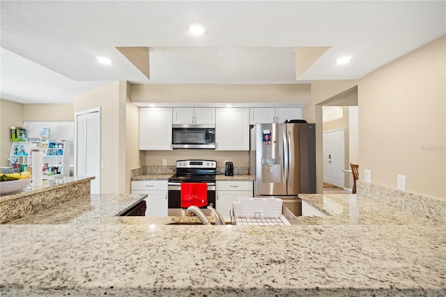 kitchen featuring light stone countertops, appliances with stainless steel finishes, white cabinets, and recessed lighting
