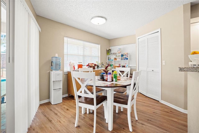 dining space featuring plenty of natural light, light wood-style flooring, and baseboards