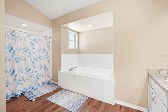 bathroom featuring a bath, vanity, a shower with curtain, wood finished floors, and baseboards