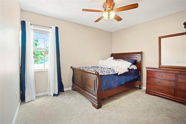 carpeted bedroom featuring baseboards, a ceiling fan, and a textured ceiling