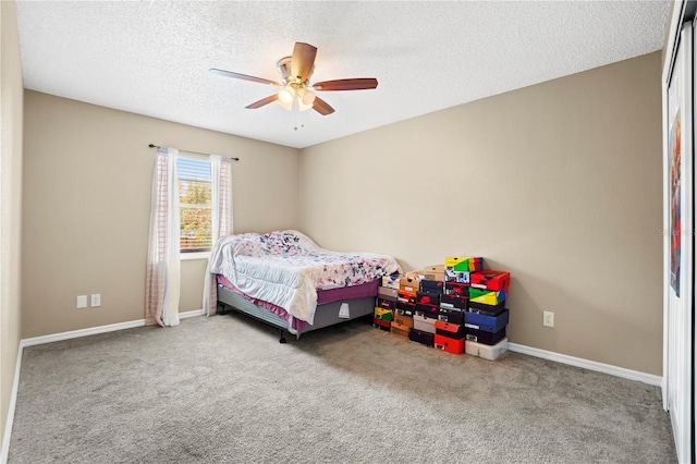 carpeted bedroom featuring a textured ceiling, baseboards, and a ceiling fan
