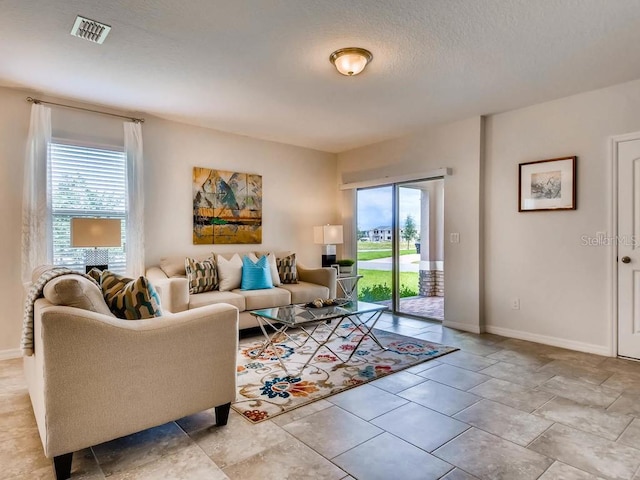 1550 Dalehurst Ln, Kissimmee, FL 34744 - living area featuring visible vents, baseboards, and a textured ceiling