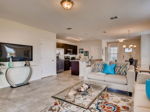 1550 Dalehurst Ln, Kissimmee, FL 34744 - living area with a notable chandelier and visible vents