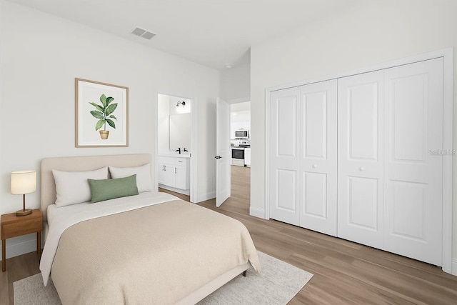 bedroom with light wood finished floors, a closet, and baseboards