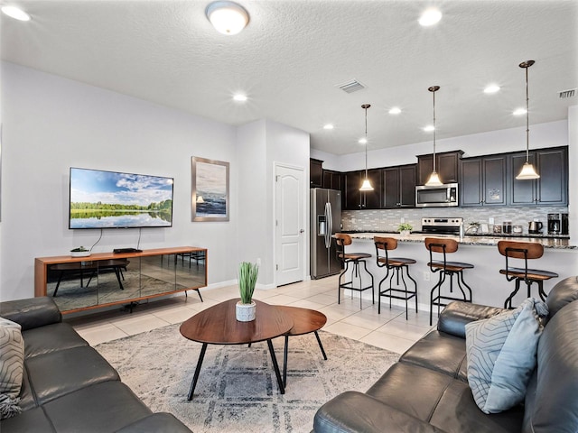 2432 Tangier Dr, Kissimmee, FL 34747 - living area featuring a textured ceiling, light tile patterned floors, visible vents, and recessed lighting