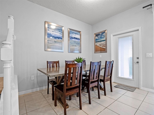 2432 Tangier Dr, Kissimmee, FL 34747 - dining room featuring baseboards, light tile patterned flooring, and a textured ceiling