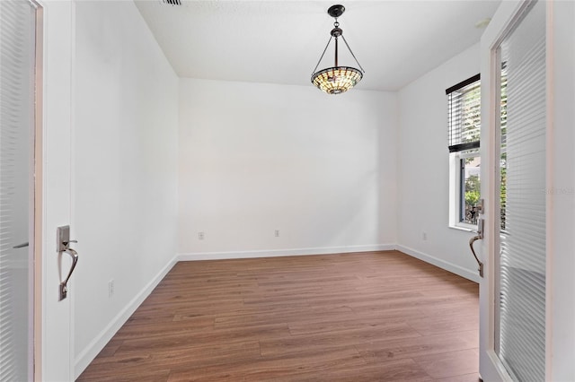 spare room featuring wood finished floors and baseboards