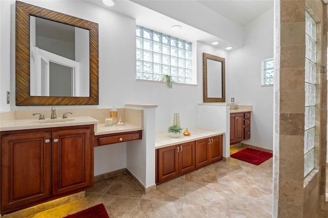 bathroom with two vanities, tile patterned floors, and baseboards