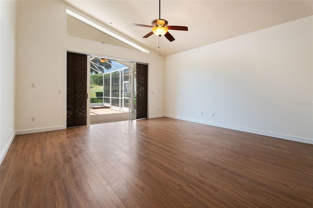 spare room featuring a ceiling fan, vaulted ceiling, wood finished floors, and baseboards