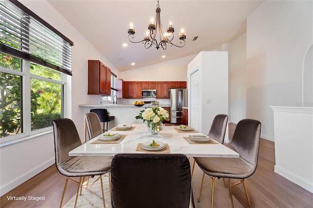 dining room with a chandelier, light wood finished floors, baseboards, vaulted ceiling, and recessed lighting