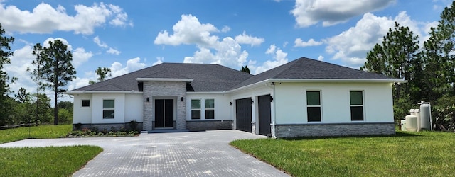 0 Sabal St, Orlando, FL 32833 - prairie-style house featuring stucco siding, decorative driveway, stone siding, a front lawn, and an attached garage