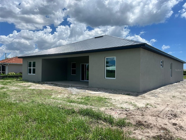 24462 Cabana Rd, Punta Gorda, FL 33955 - back of property with stucco siding, a patio, and a metal roof