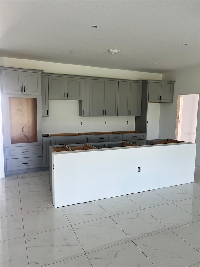 24462 Cabana Rd, Punta Gorda, FL 33955 - kitchen with light marble finish flooring, gray cabinets, and a kitchen island