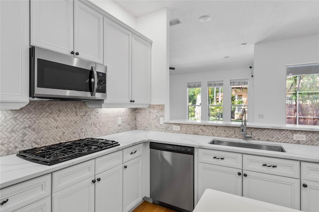 1803 Glenbay Ct, Windermere, FL 34786 - kitchen featuring white cabinetry, appliances with stainless steel finishes, decorative backsplash, and a sink