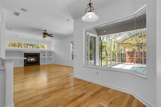 1803 Glenbay Ct, Windermere, FL 34786 - unfurnished living room with baseboards, light wood-style flooring, ceiling fan, and a healthy amount of sunlight