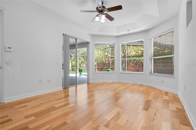 1803 Glenbay Ct, Windermere, FL 34786 - unfurnished room with ceiling fan, a textured ceiling, baseboards, a tray ceiling, and light wood-style flooring