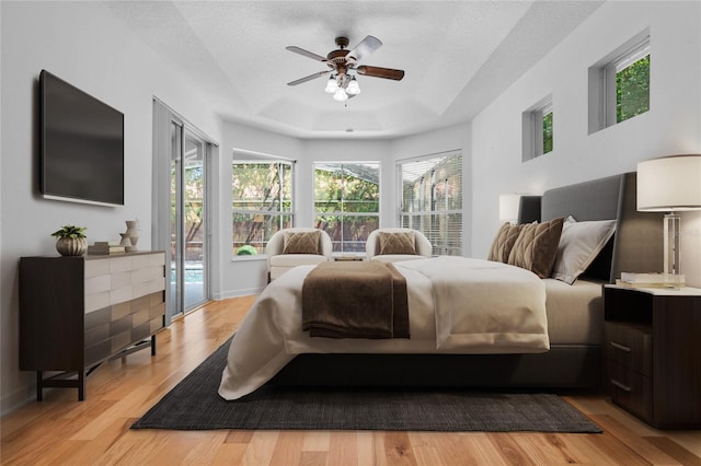 1803 Glenbay Ct, Windermere, FL 34786 - bedroom with multiple windows, a tray ceiling, light wood finished floors, and access to exterior