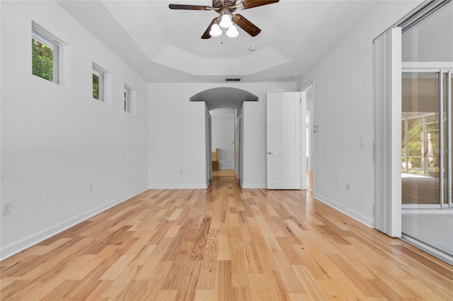 1803 Glenbay Ct, Windermere, FL 34786 - spare room with a healthy amount of sunlight, ceiling fan, arched walkways, light wood-type flooring, and a raised ceiling
