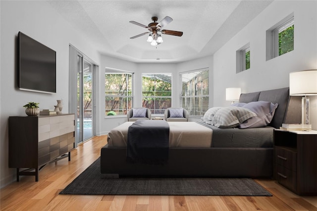 1803 Glenbay Ct, Windermere, FL 34786 - bedroom featuring access to outside, a textured ceiling, light wood finished floors, and a tray ceiling