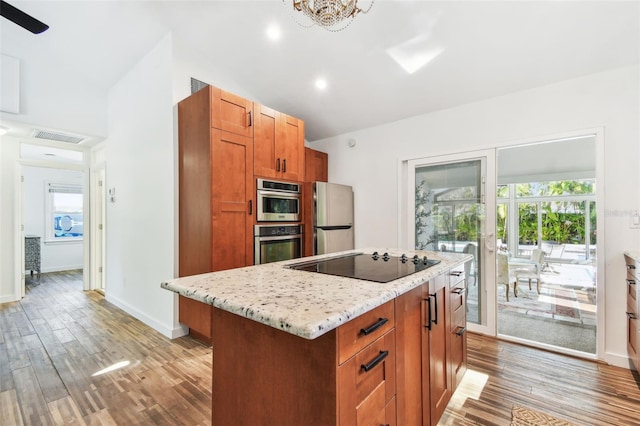913 Tennessee Ln, Sarasota, FL 34234 - kitchen featuring black electric cooktop, freestanding refrigerator, vaulted ceiling, light wood-style flooring, and baseboards