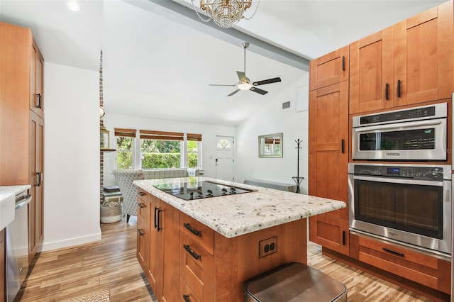 913 Tennessee Ln, Sarasota, FL 34234 - kitchen featuring appliances with stainless steel finishes, light wood-style flooring, a center island, and light stone counters