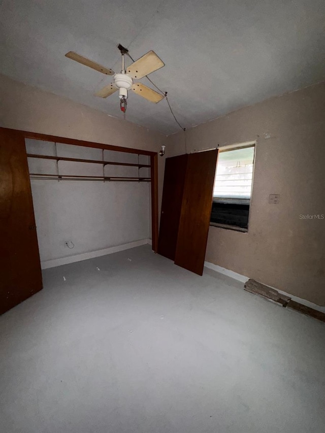 unfurnished bedroom with concrete flooring, baseboards, and a ceiling fan