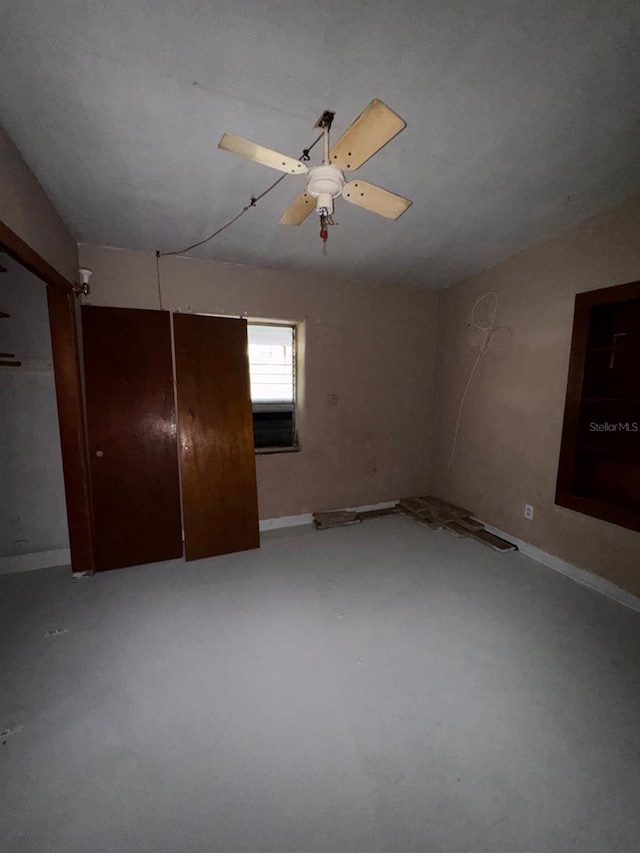 empty room with concrete flooring and a ceiling fan