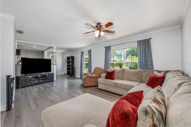 living room with crown molding, wood finished floors, ceiling fan, and baseboards