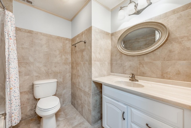 full bathroom featuring tile walls, a tile shower, toilet, crown molding, and vanity