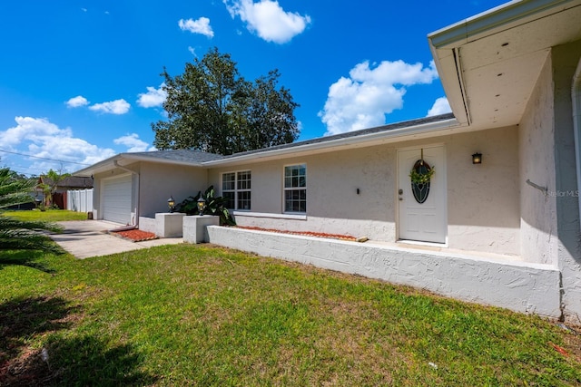 view of front of property with a garage, stucco siding, and a front lawn