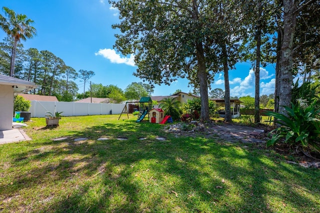 view of yard with a fenced backyard and a playground