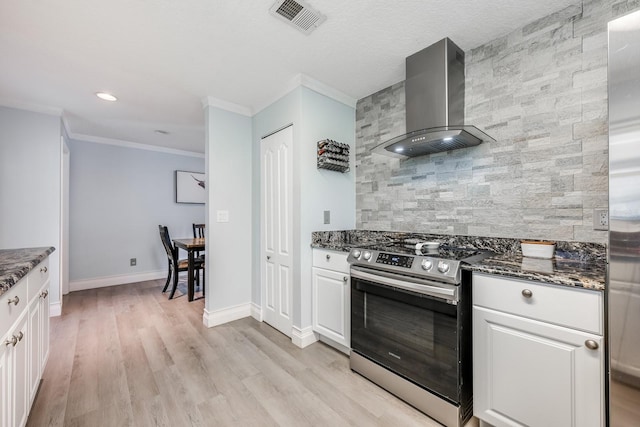 kitchen featuring dark stone countertops, visible vents, tasteful backsplash, wall chimney exhaust hood, and stainless steel range with electric stovetop