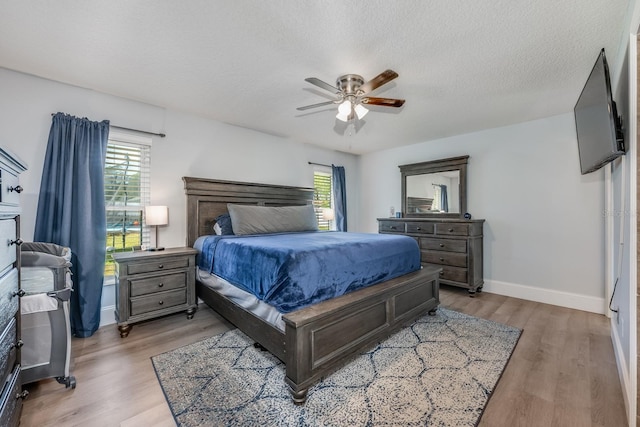bedroom with multiple windows, baseboards, and wood finished floors