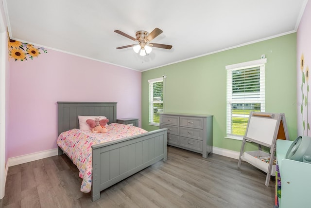 bedroom featuring light wood-style flooring, multiple windows, ornamental molding, and baseboards
