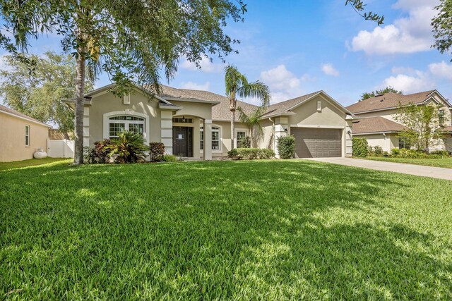 235 Largovista Dr, Oakland, FL 34787 - mediterranean / spanish-style home featuring driveway, stucco siding, an attached garage, and a front lawn