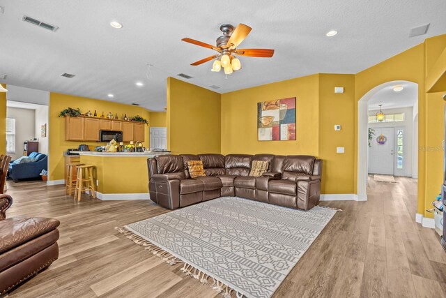 235 Largovista Dr, Oakland, FL 34787 - living area featuring visible vents, ceiling fan, light wood-type flooring, and arched walkways
