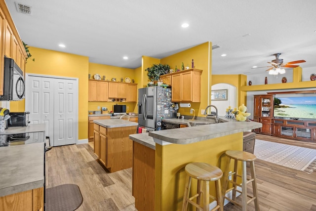 235 Largovista Dr, Oakland, FL 34787 - kitchen with visible vents, stainless steel fridge, a sink, a peninsula, and black microwave