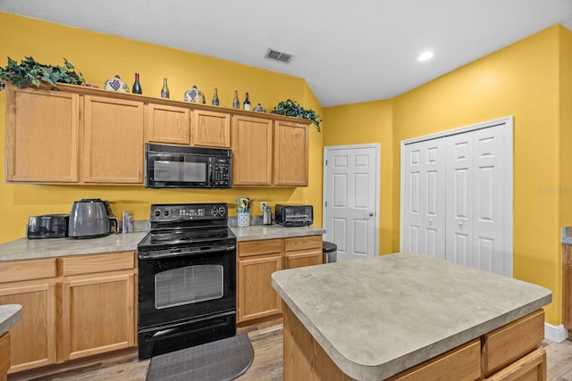 235 Largovista Dr, Oakland, FL 34787 - kitchen featuring visible vents, light countertops, black appliances, light wood finished floors, and a kitchen island