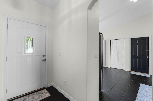 37 Lindsay Dr, Palm Coast, FL 32137 - entrance foyer with dark tile patterned flooring, arched walkways, baseboards, and lofted ceiling