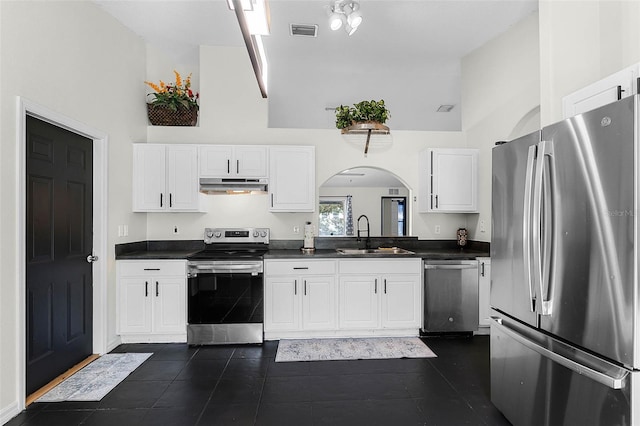 37 Lindsay Dr, Palm Coast, FL 32137 - kitchen with high vaulted ceiling, under cabinet range hood, dark countertops, a sink, and stainless steel appliances