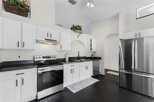 37 Lindsay Dr, Palm Coast, FL 32137 - kitchen featuring visible vents, arched walkways, dark countertops, under cabinet range hood, and stainless steel appliances